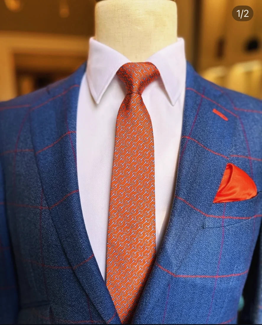 Blue checked jacket with an orange silk tie and pocket square